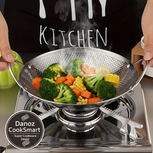 Metallic wok on a stove with a person wearing a black apron with 'KITCHEN' text.