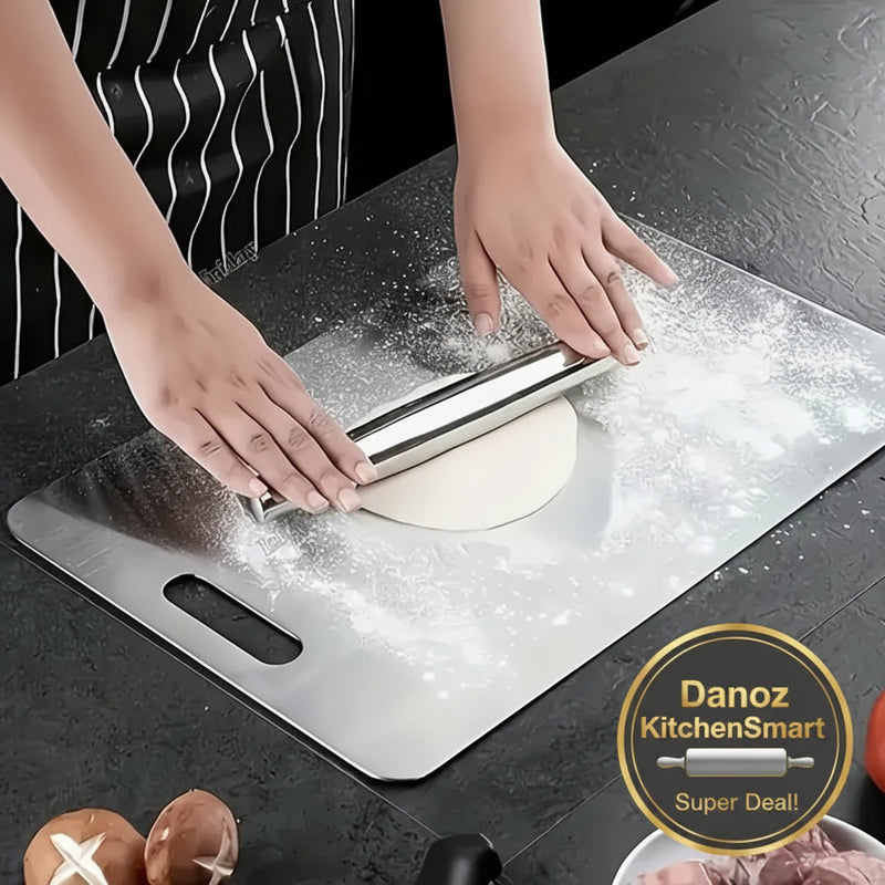 Person using a rolling pin on dough on a stainless steel surface