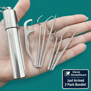 Set of metal ear cleaning tools with a container held in a hand against a teal background