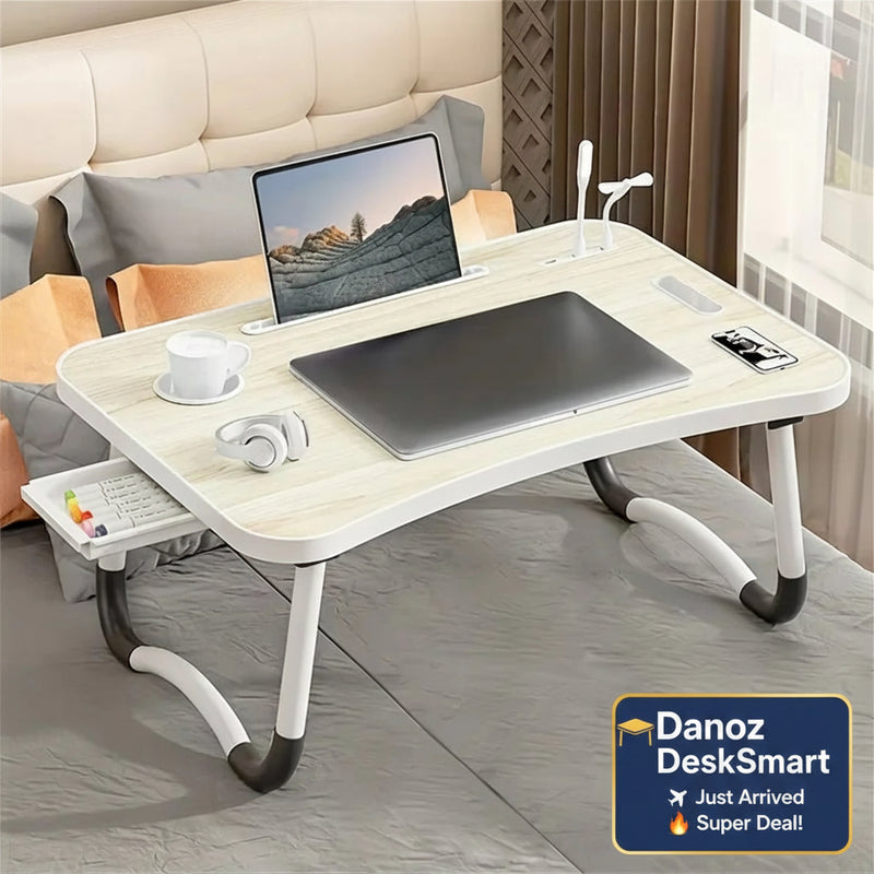 Portable laptop desk with a laptop, mouse, and other items on a sofa.