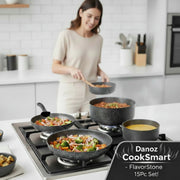 Set of black speckled cookware including pots, pans, and lids on a white background