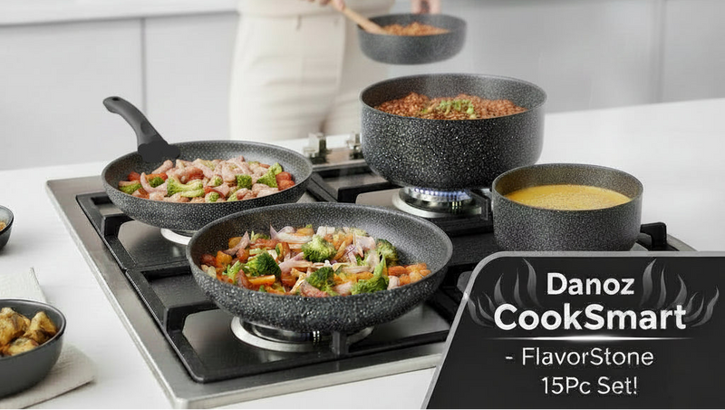 Set of black speckled cookware including pots, pans, and lids on a white background