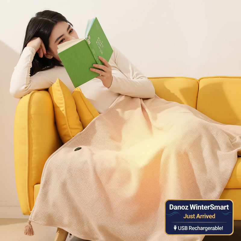 Woman reading a green book on a yellow couch with a heated pink blanket