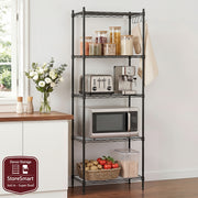 Black metal kitchen rack with appliances and items on a wooden countertop.