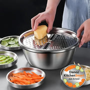 Person using a metal vegetable grater with various vegetables on a table