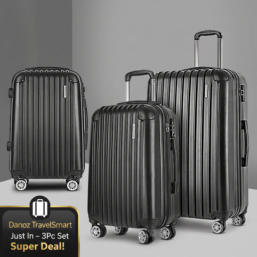 Three black suitcases of different sizes on a gray background