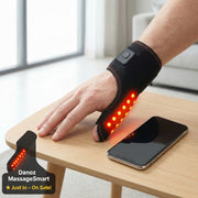 Hand wearing a black wrist brace with red lights on a wooden table, next to a smartphone.