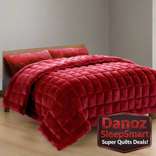 A burgundy faux mink quilt with baffle box design on a bed, accompanied by matching pillowcases.