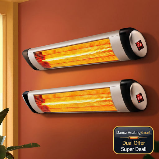 Two wall-mounted infrared heater strips glowing with orange light on a terracotta-colored wall, with a window frame and plant leaves visible at the edges.