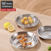 Metallic grilling baskets with food on a beige surface