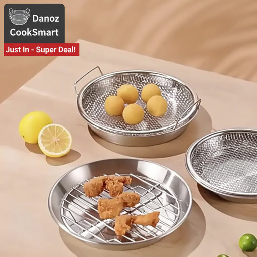 Metallic grilling baskets with food on a beige surface
