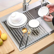 Dish drying rack with dishes and cutlery on a kitchen counter