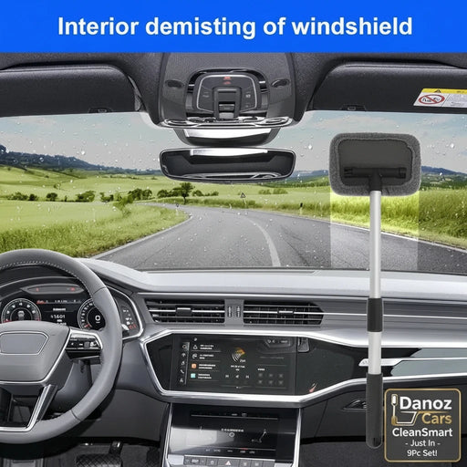 An interior car windshield demisting brush with a long handle and soft gray sponge head, shown hanging in the windshield area of a modern car dashboard. The image includes a blue banner at the top reading 'Interior demisting of windshield' and a scenic road view through the windshield.