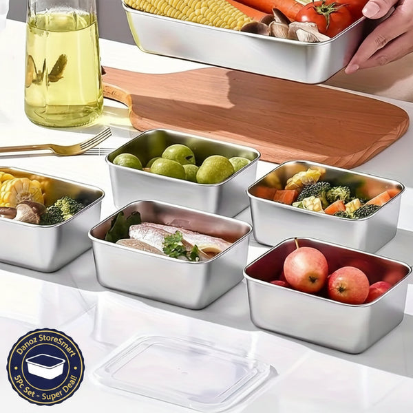Set of stainless steel food containers with food on a table