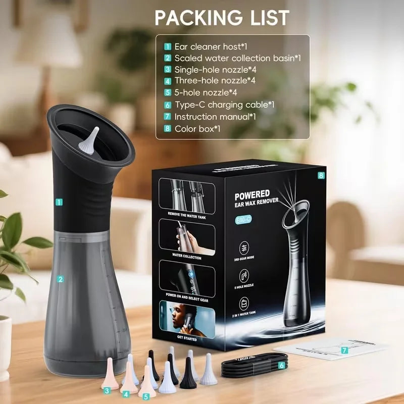 Powered ear wax remover with packaging and accessories on a table.