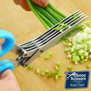 Scissors cutting green onions on a wooden surface