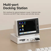Multi-port docking station with screen displaying icons on a beige surface.