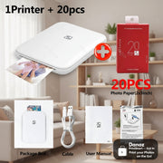 Portable photo printer with photo paper, packaging, cable, and user manual on a white background