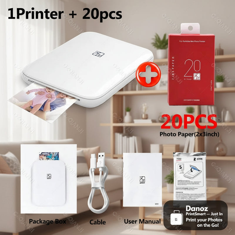 Portable photo printer with photo paper, packaging, cable, and user manual on a white background