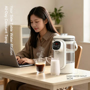 Woman using a laptop with a water station and glass of coffee on a table.