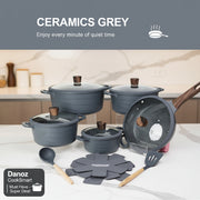 Set of grey cookware with lids, utensils, and a mat on a white background.