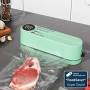 Green wireless handheld vacuum sealer on a kitchen counter with a piece of meat and tomatoes.