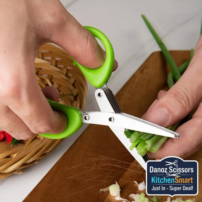 Person using green-handled scissors to trim green onions on a wooden cutting board.