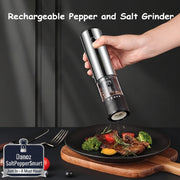 Hand holding a rechargeable pepper and salt grinder over a plate of food with utensils on a dark surface.