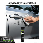 A hand wipes a gray car door with a cloth after scratching it, with the text 'Say goodbye to scratches' at the top and a tube of Scratch Wax product shown below on a white background.