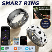 Two smart rings displayed on a soft white fabric background, one in polished black and one in silver with a black-and-white hexagon pattern. The image includes smartphone app screens showing fitness and video-gesture controls, the text 'SMART RING,' and feature callouts for steps, calories, and distance.