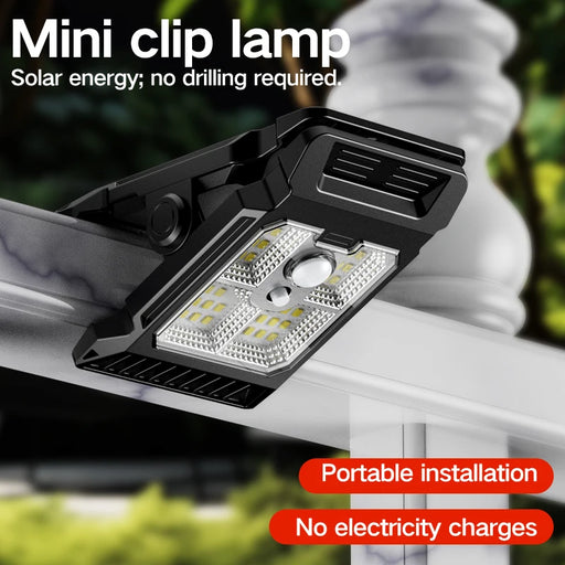 Mini clip lamp with solar energy feature on a blurred outdoor background
