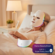 A white LED facial therapy mask shown from two angles on a clean white background, with multicolor light glowing through the eye and side cutouts.