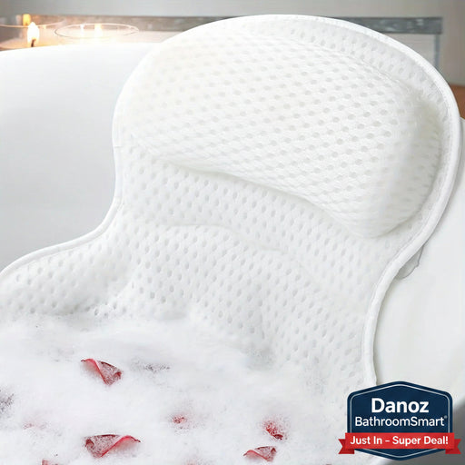 White bath pillow in a bathtub with bubbles and rose petals.