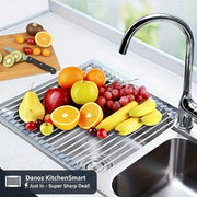 Fruit on a stainless steel sink mat with a kitchen faucet in the background