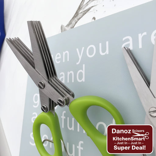 Green-handled scissors cutting through a piece of paper with text.