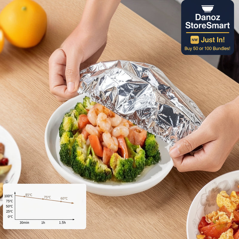 Person preparing a dish with shrimp and broccoli on a wooden table, using a foil pack.