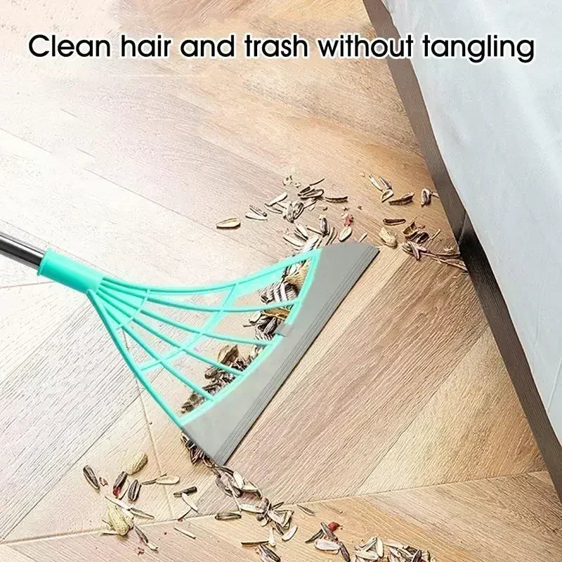 Teal leaf rake cleaning hair and trash from a wooden floor.