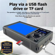 A gray electronic media player or DVD player with a blue screen and digital control panel, shown with a USB flash drive inserted and a cable plugged in. Text at the top says it can be played via a USB flash drive or TF card.