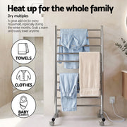Towel rack with towels and clothes in a bathroom setting, with text about heating up for the whole family.