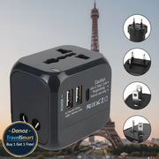 Black travel adapter with multiple plug sockets against a blurred Eiffel Tower background