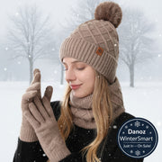 Woman wearing a beige knit hat with pom-pom, scarf, and gloves on a white background