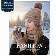 Woman wearing a beige knit hat with pom-pom, scarf, and gloves on a light gray background.