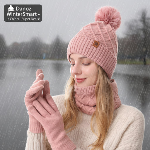 Woman wearing a pink knit hat with a pom-pom, scarf, and gloves on a white background