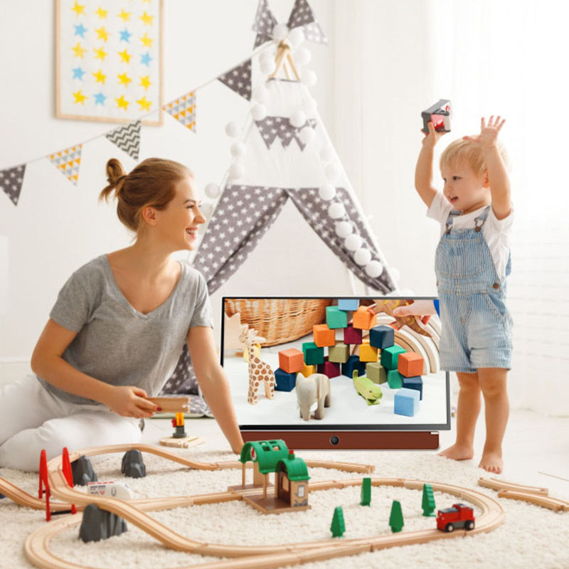 Woman and child playing with a wooden train set in a room with colorful decorations.