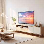 A modern living room scene featuring a light wood and white media console with a television mounted above it, styled with a floor lamp, coffee table, and decorative vases.