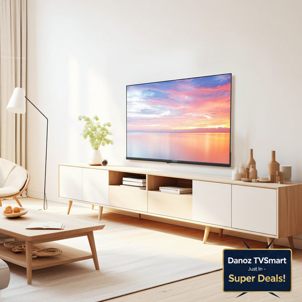 A modern living room scene featuring a light wood and white media console with a television mounted above it, styled with a floor lamp, coffee table, and decorative vases.