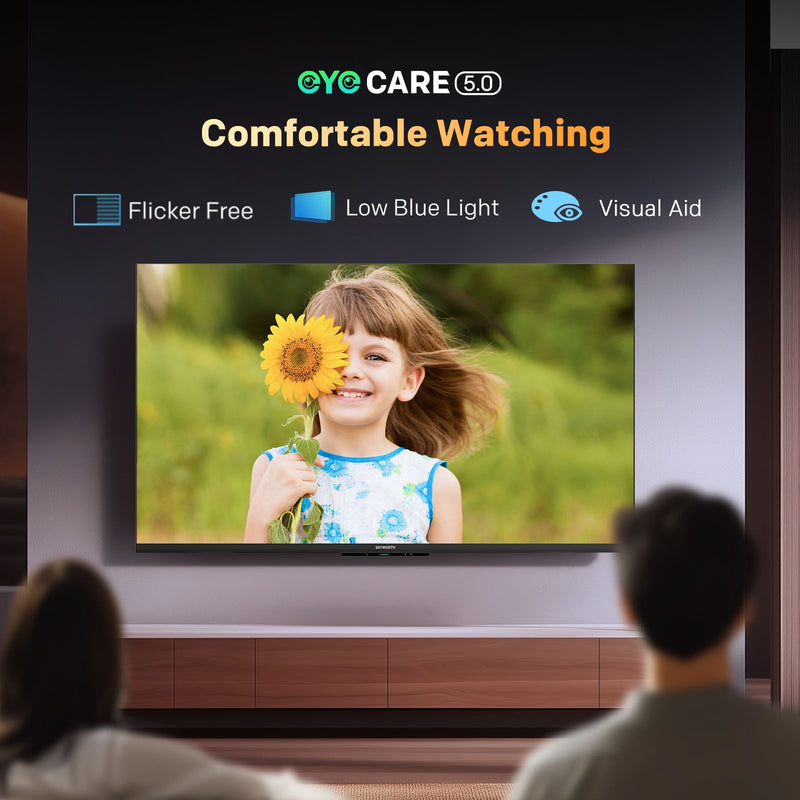 A large wall-mounted TV shows a smiling girl holding a sunflower, with two people seated in front of it. The TV screen displays the text 'EYCCARE 5.