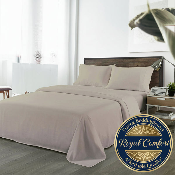 A king-sized bed with a beige bamboo blended sheet and two pillowcases, in a bedroom setting.