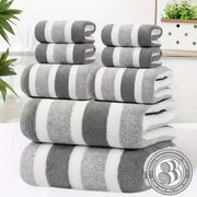 Stack of gray and white striped towels on a white surface with a blurred indoor background.