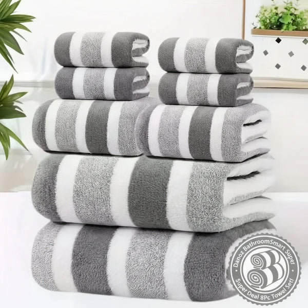 Stack of gray and white striped towels on a white surface with a blurred indoor background.